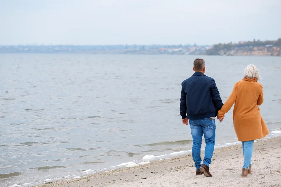 Older couple walking along a beach