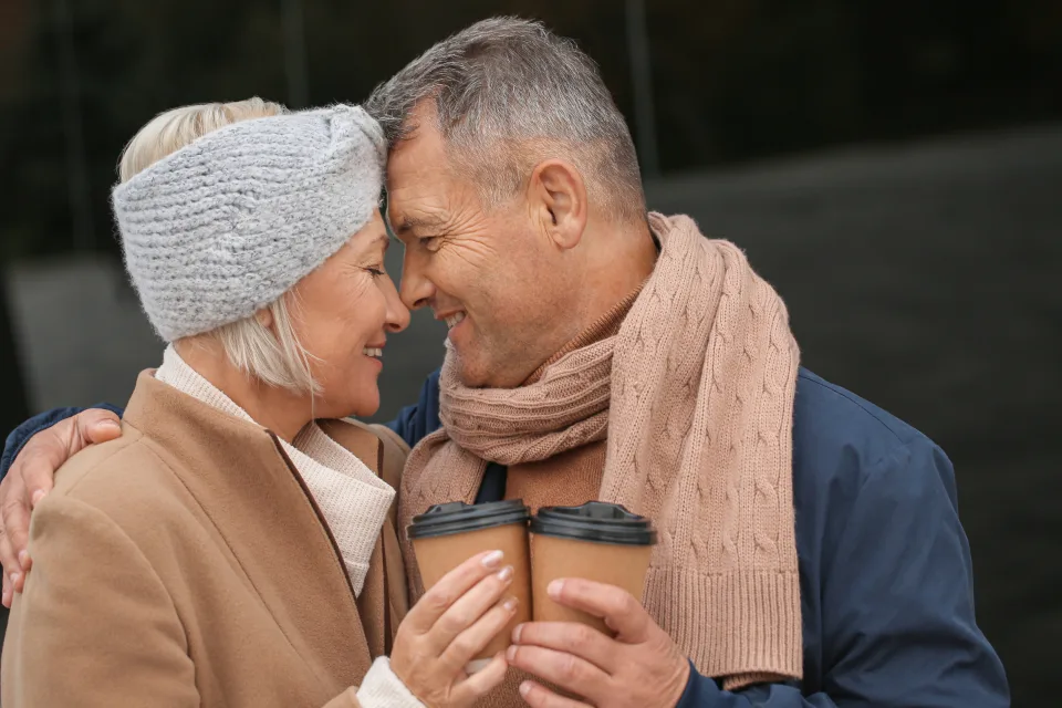 Older couple talking outdoors with coffee